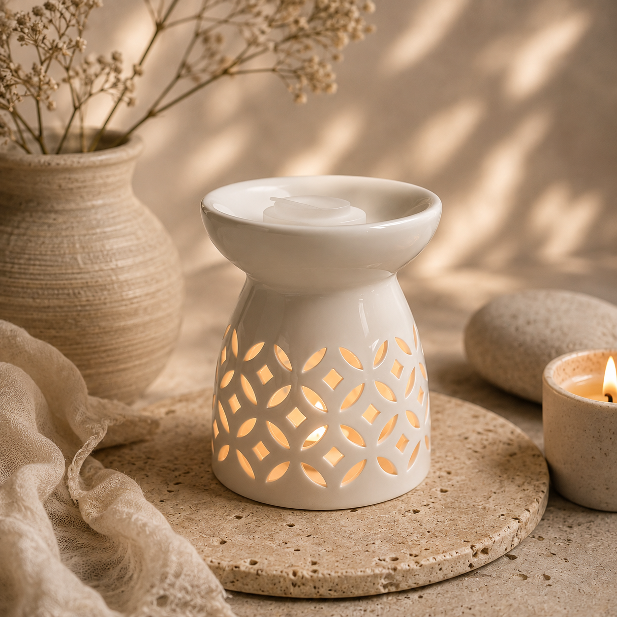 White ceramic diffuser burner glowing on a stone tray in a warm neutral setting