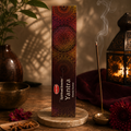 HEM Yantra spiritual incense packaging beside a lantern and burning incense