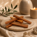 Palo Santo holy wood sticks arranged on a stone tray in warm candlelight